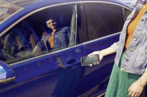 mujer abriendo volkswagen passat con su smartphone